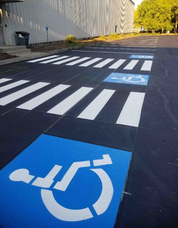Freshly sealcoated commercial parking lot with new yellow striping, AC Moate Industries